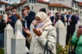 Sarajevo, Bosnia and Herzegovina, May 2020, An elderly Muslim woman with a hijab pays tribute to her sons who died in the 1995 war