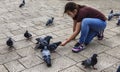 Sarajevo, Bosnia - May 2, 2022 - Young girl feeds the pigeons in a park Royalty Free Stock Photo