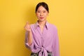 Saranghae. Beautiful young Asian woman making Korean finger mini heart gesture on yellow studio background