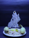 Saraswathi Pooja and Ayudha Pooja Celebrations - Silver idol Murugan with banana, flowers and pori on black background. Royalty Free Stock Photo