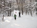 Saratov, Russia - Jan,2022: family cross-country skiing in a beautiful winter forest, back view, slow motion. Royalty Free Stock Photo