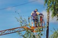 The electrician is changing the wires on the pole.