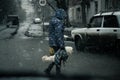 Saratov, Russia - 03/14/2020: Street photo, city life, a woman carrying a dirty dog in her hands as a bag across the road in bad