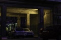 Cars parked in the arch of the Soviet apartment house in the purple light of the evening