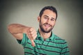 Sarcastic young man showing thumbs down sign hand gesture Royalty Free Stock Photo