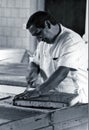 SARDEGNA, ITALY, 1970 - Pastry chef carefully cuts a sponge cake prepared in his workshop