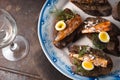 Sardines, quail egg on rye bread on a ceramic plate and glass Royalty Free Stock Photo