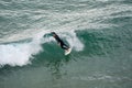 Surfers catch large waves at the beach at Praia do Beliche in the Algarve region of Portugal