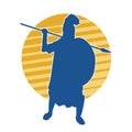 Silhouette of a roman soldier wearing armor suit in pose with spear weapon and metal shield. Royalty Free Stock Photo