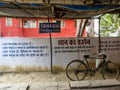 A bicycle parked beside a white wall with philosophical text written in the Hindi
