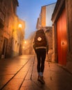 Lone Pilgrim Girl on Street in Old Town Sarria Spain early morning on Way of St James Camino de Santiago