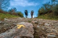 Sarria, Spain - Two Pilgrims Hiking up a Hill with the Yellow Arrow Way Mark outside Sarria along the Way of St James el Camino