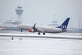 SAS Scandinavian Airlines Boeing 737-800 LN-RRJ in Munich Airport, snow Royalty Free Stock Photo