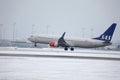 SAS Scandinavian Airlines Boeing 737-800 LN-RRJ in Munich Airport, snow Royalty Free Stock Photo