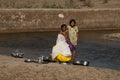 Indian family washing the cooking utensils in the Hiran River.