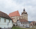 Fortified Church St. Stephen and the clock tower standing on the road passing through the village of Saschiz in Romania Royalty Free Stock Photo