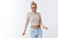 Sassy and cool attractive glamour blond woman in glasses and cropped top dancing shaking breast and hands singing