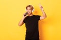 Sassy handsome asian guy in headphones, playing karaoke app, singing into mobile phone microphone, showing peace gesture