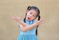 Sassy little Asian kid girl with funny face and expression cross one`s arm Royalty Free Stock Photo