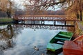 Sasto lake with a boat and a duck in the front and a wooden bridge