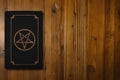 Satanic book on a wooden desk