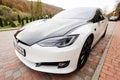 Sataniv, Ukraine - October 23, 2022: Dual color black and white Tesla Model S on pavement at utumn forest