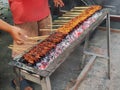 When Sate is being grilled using wood charcoal.