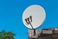 Satellite dish antenna communication and tv signal technology on the roof of the house against the background of blue sky Royalty Free Stock Photo