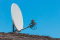Satellite dish antenna communication and tv signal technology on the roof of the house against the background of blue sky Royalty Free Stock Photo