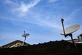 Satellite dish antenna installed on roof top over blue sky background Royalty Free Stock Photo