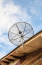 Satellite dish antenna for television on house roof Royalty Free Stock Photo