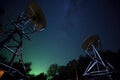 a satellite dish array under star-lit night sky