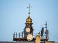 Satellite dish on the dome of the temple with a cross