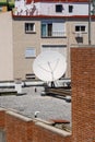 Satellite Dish On The Gravel Roof Of A Building