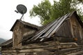 Satellite dish on old log cabin in disrepair, Jackson, Wyoming.
