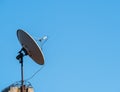 Satellite dish or parabolic antenna on the roof of a building against blue sky Royalty Free Stock Photo