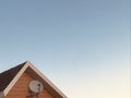 The satellite dish on the roof against the blue sky. Royalty Free Stock Photo