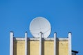 Satellite dish on the roof of a building against the blue sky Royalty Free Stock Photo