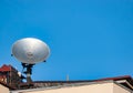 Satellite dish on the roof of the building against the blue sky Royalty Free Stock Photo