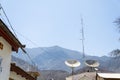 Satellite dish on the roof of the house with radio tower on sunny day cloud blue sky. Royalty Free Stock Photo