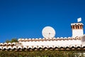 Satellite dish and TV antennas on the house roof with blue sky background. Royalty Free Stock Photo