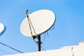 Satellite dish and TV antennas on the house roof with blue sky background Royalty Free Stock Photo