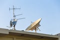 Satellite dish and TV antennas on the house roof with blue sky background Royalty Free Stock Photo