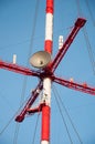 Satellite dishes and antennas on the red-white telecommunication tower against blue sky Royalty Free Stock Photo