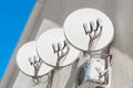 Satellite dishes antennas television communication signal communications on the wall of the house against the background of blue