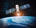 Satellite, hovering above the earth with view of sunrise Royalty Free Stock Photo