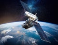 Satellite, hovering above the earth with view of sunrise Royalty Free Stock Photo