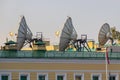 Satellite parabolic antennas on building roof closeup in sunny morning Royalty Free Stock Photo