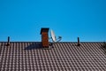 Satellite television antenna attached to the chimney of a rural house. Royalty Free Stock Photo