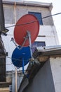Satellite TV dish antennas installed on the eaves of poor shanty houses in a depressed neighborhood